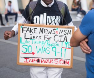 Ein Demonstrant in den USA wirbt für die rechtspopulistische Internetplattform Infowars.com.